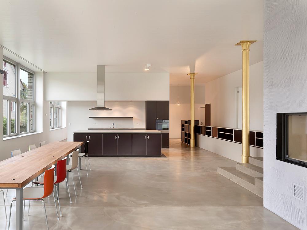  Architektur-Reportage: Nachhaltig umgenutzt: Die Küche setzt mit den goldenen Säulen farbige Akzente