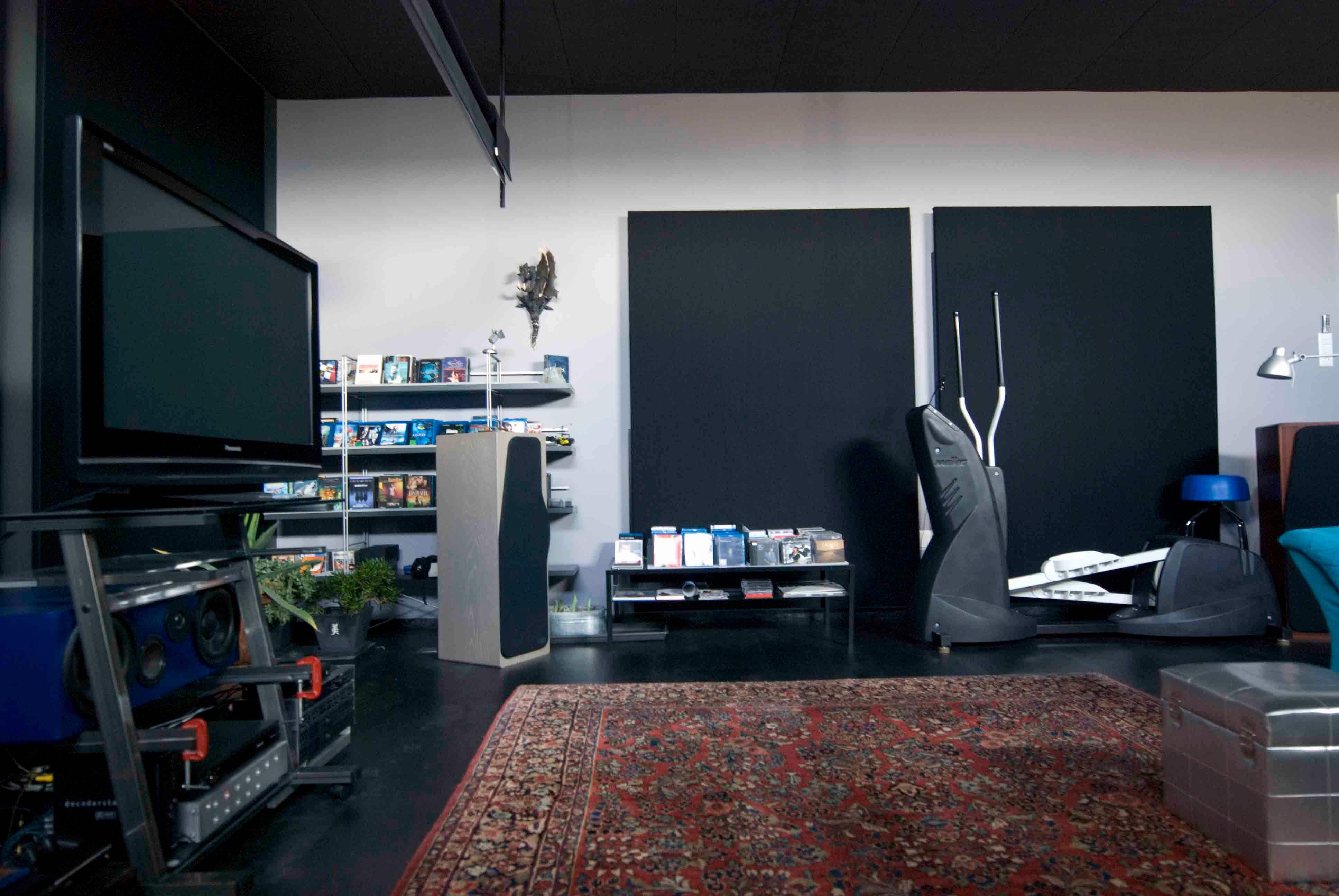 Architektur-Reportage Frick Hanglage: dunkler Wohnbereich mit TV und Fitnessgeräten