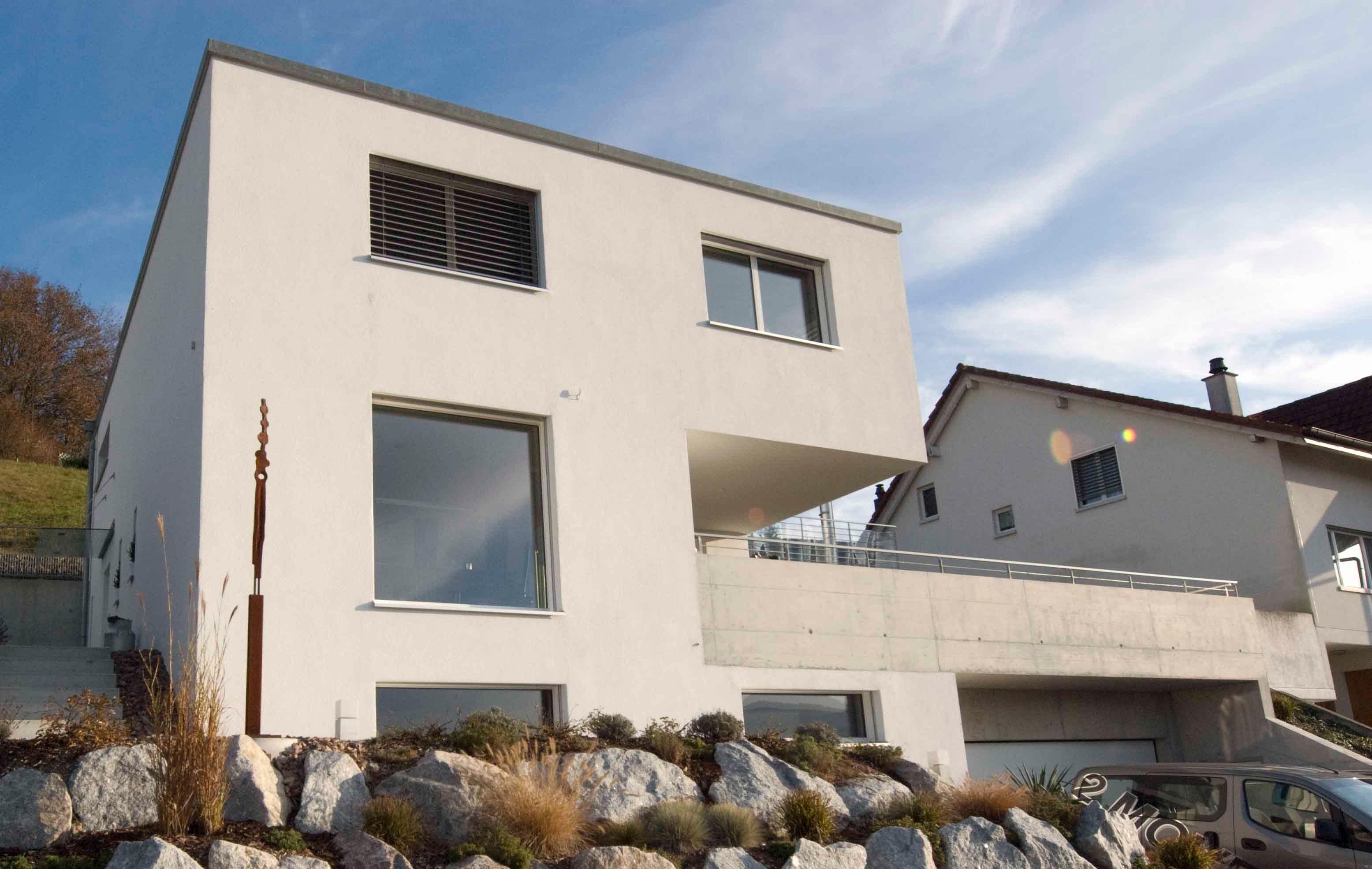  Architektur-Reportage Frick Hanglage: Aussenansicht modernes Einfamilienhaus mit Steinmauer