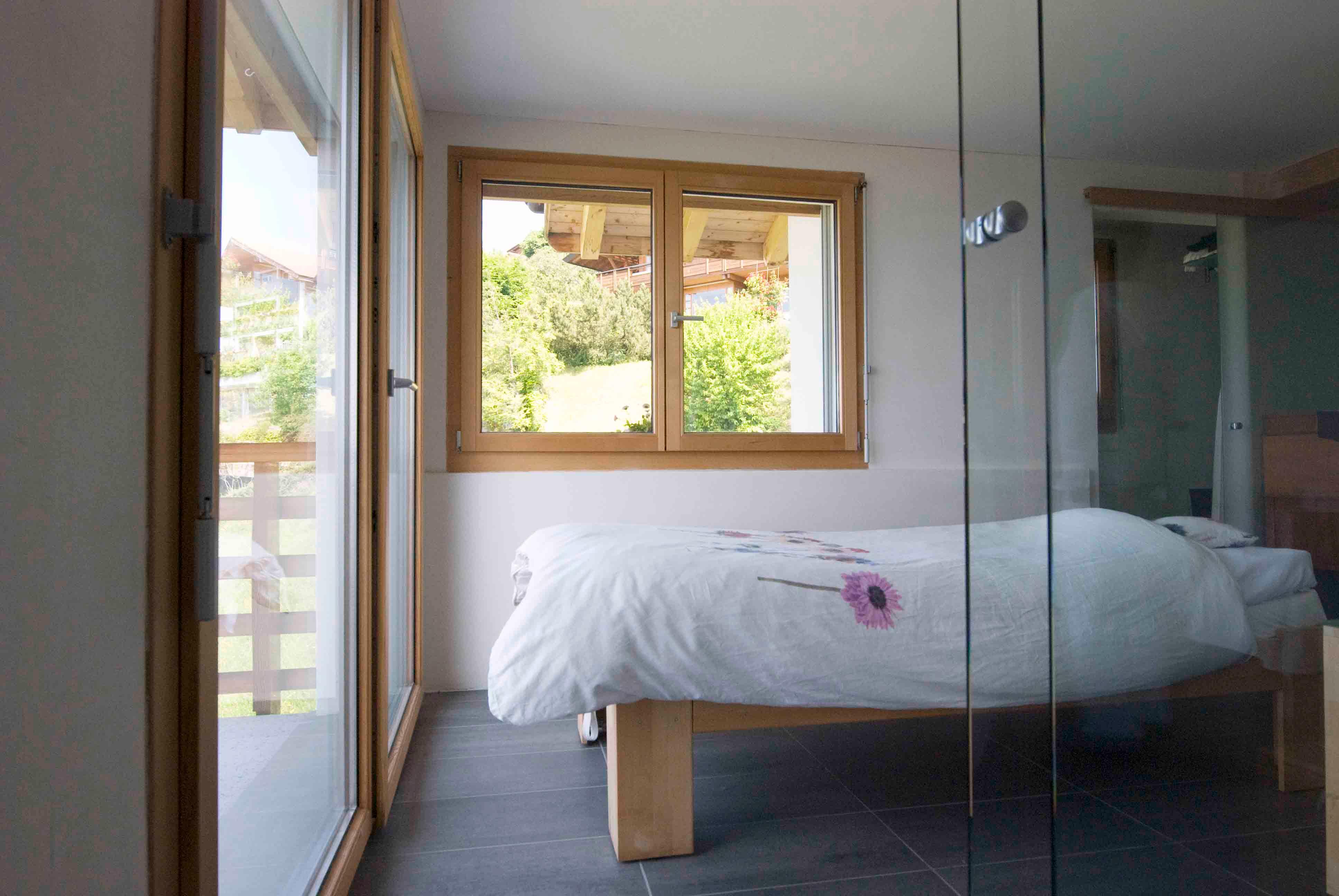 Architektur-Reportage Heiligenschwendi Umweltkranke: Schlafzimmer mit zwei Holzfenstern