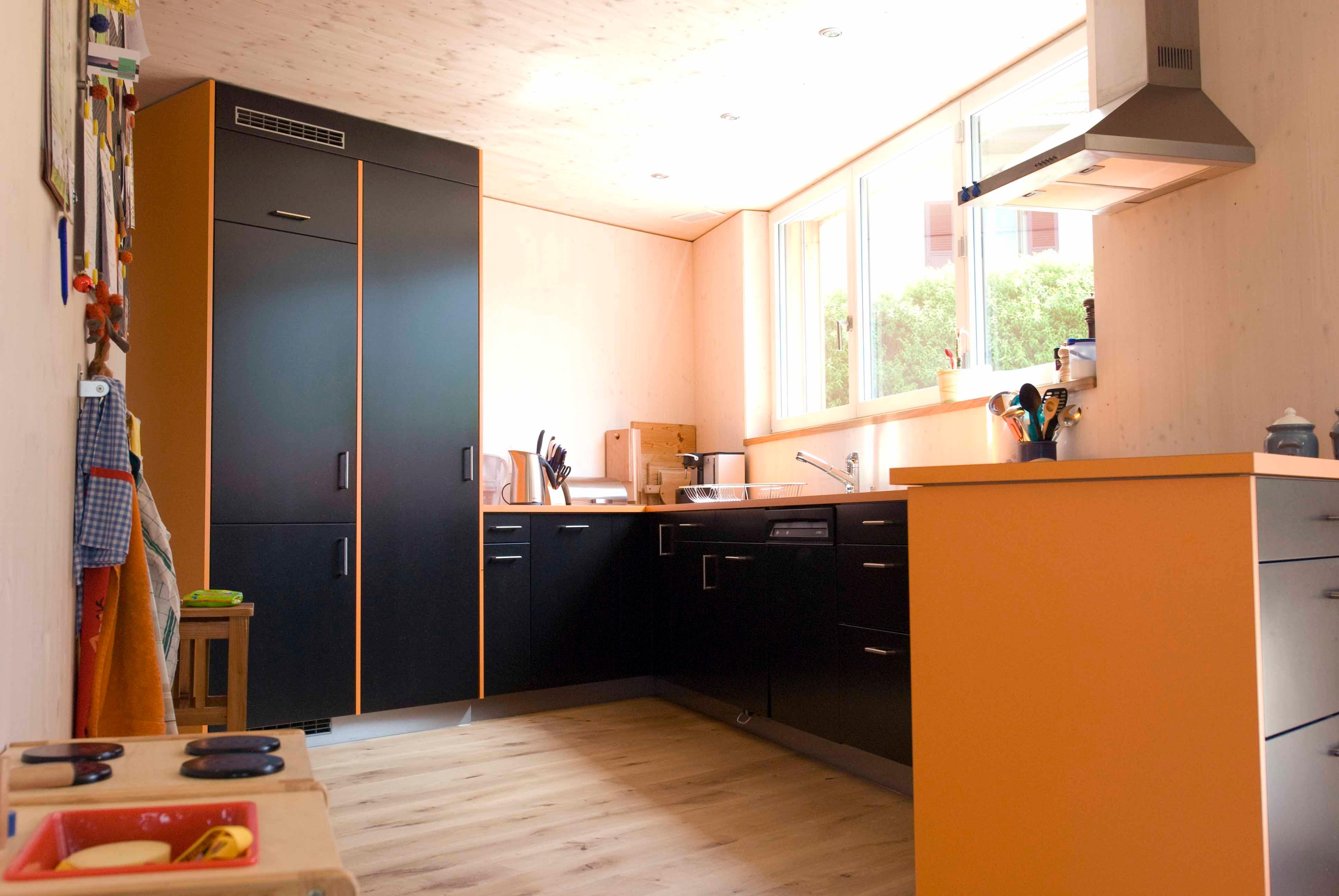  Architektur-Reportage Hessigkofen Sechseck Decke: in der Küche bringen orange und schwarze Elemente Farbe ins Haus