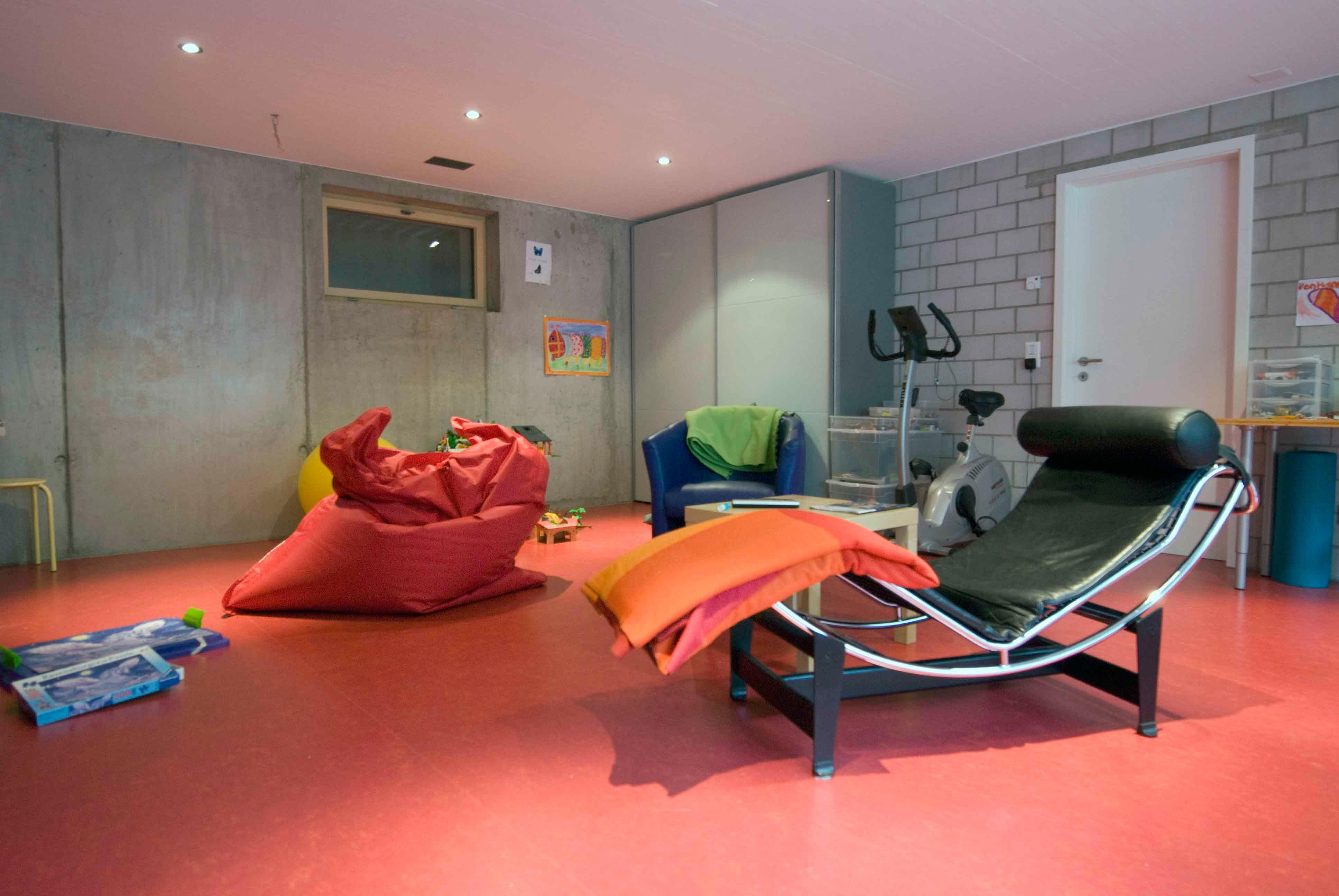 Architektur-Reportage Kirchberg Minergie-P: farbenfrohes Fernsehzimmer im Untergeschoss