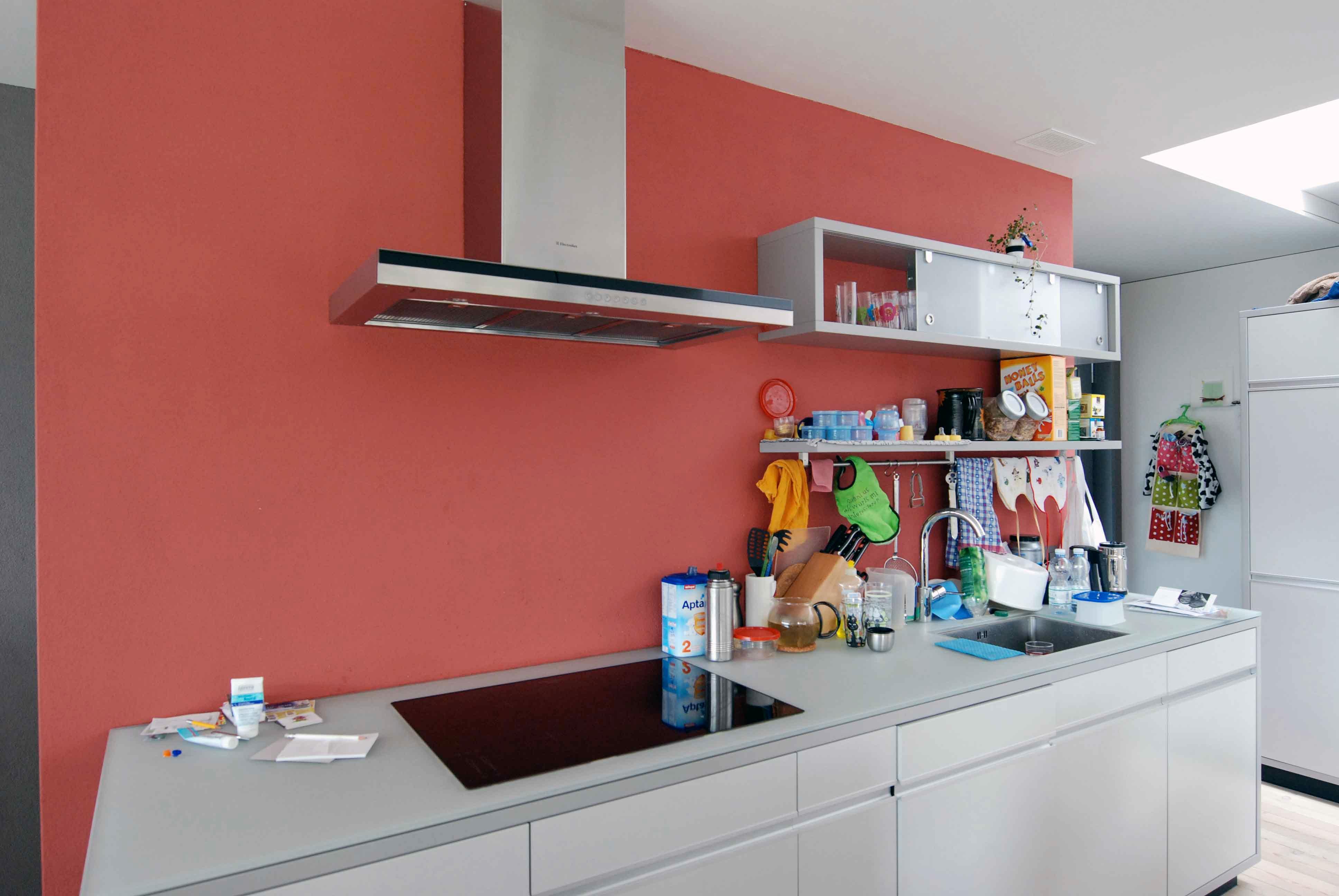 Architektur-Reportage Münsigen Niggli Luder: rote Wand in der Küche passt ins Farbkonzept