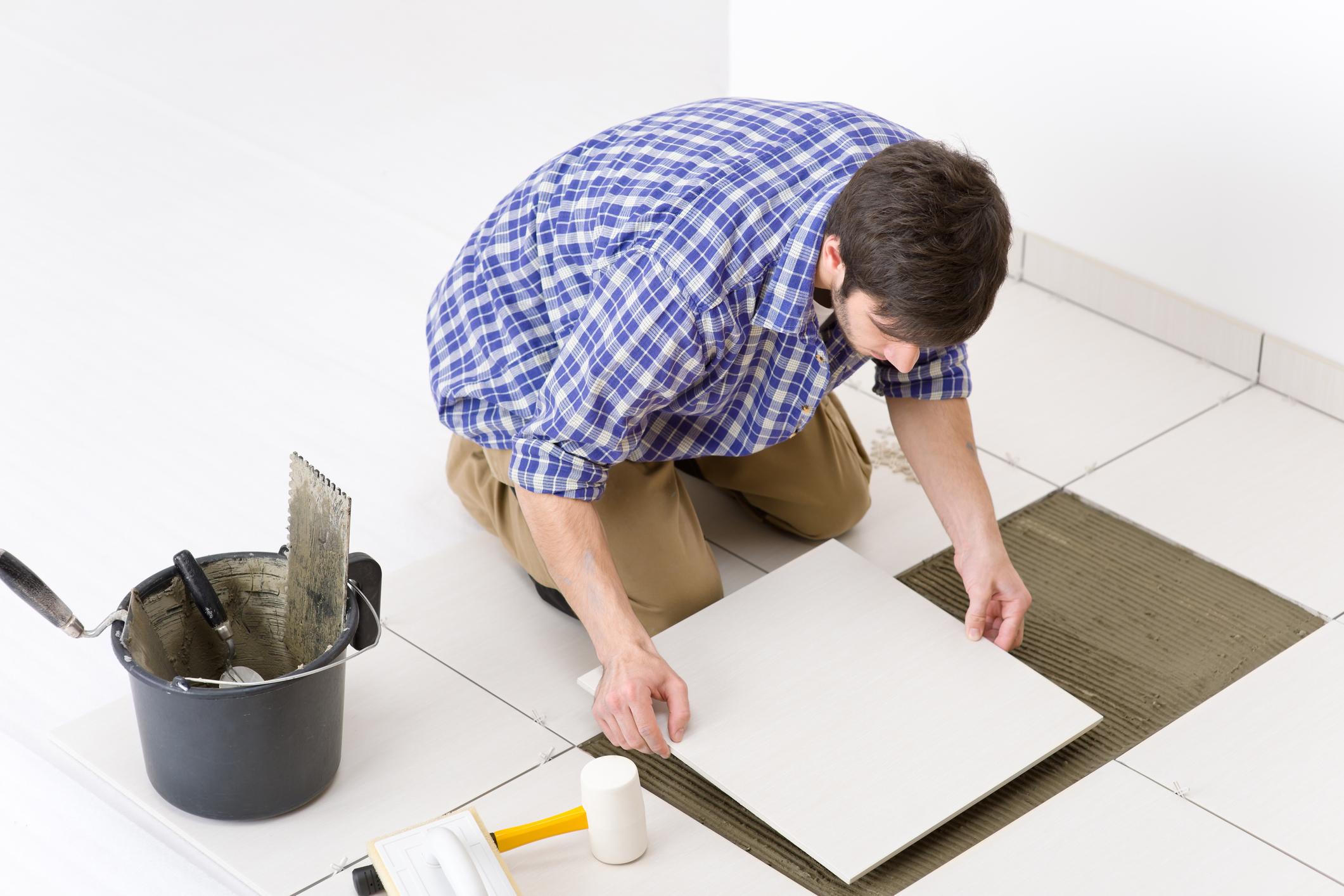 DIY: Heimwerker ersetzt Bodenplatten mit Spatel, Leim und Hammer