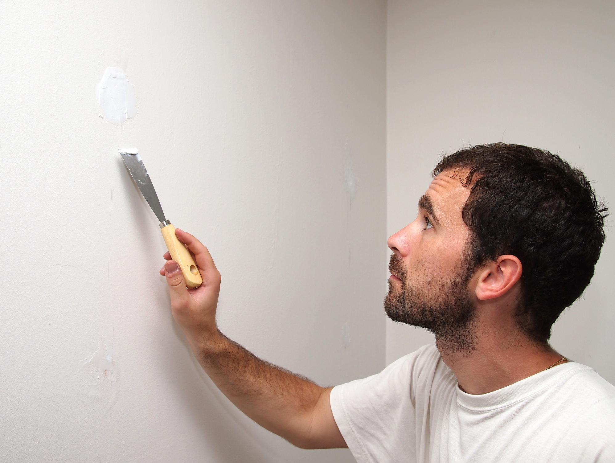 DIY: mit einem Spatel kann man Risse an der Wand beheben 