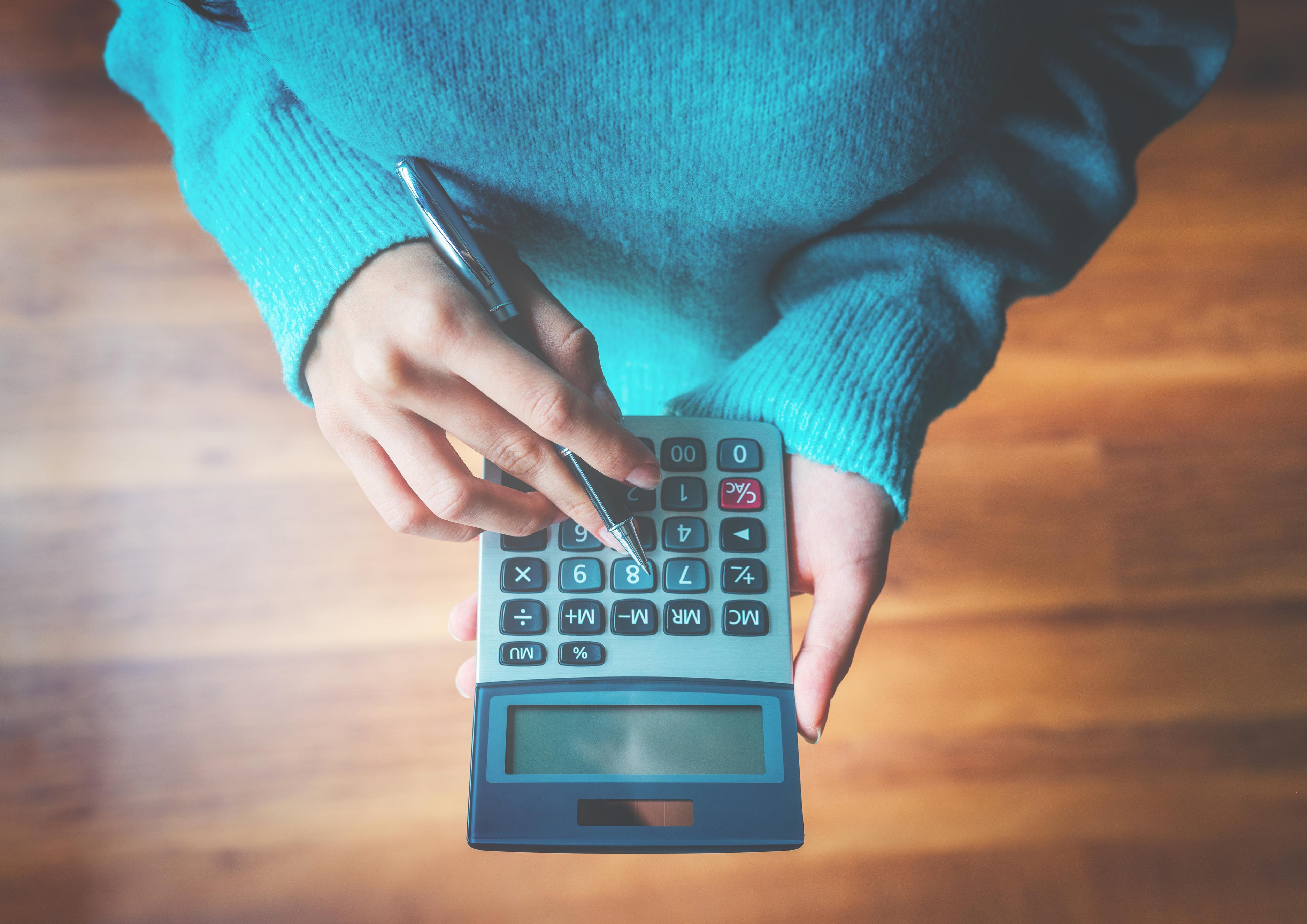 Une femme avec une calculatrice pour calculer les impôts